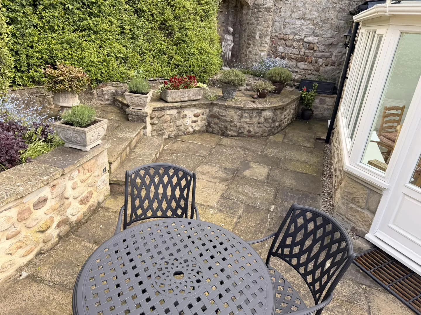Walled stone patio clean after cleaning by Hopkins Exterior Cleaning